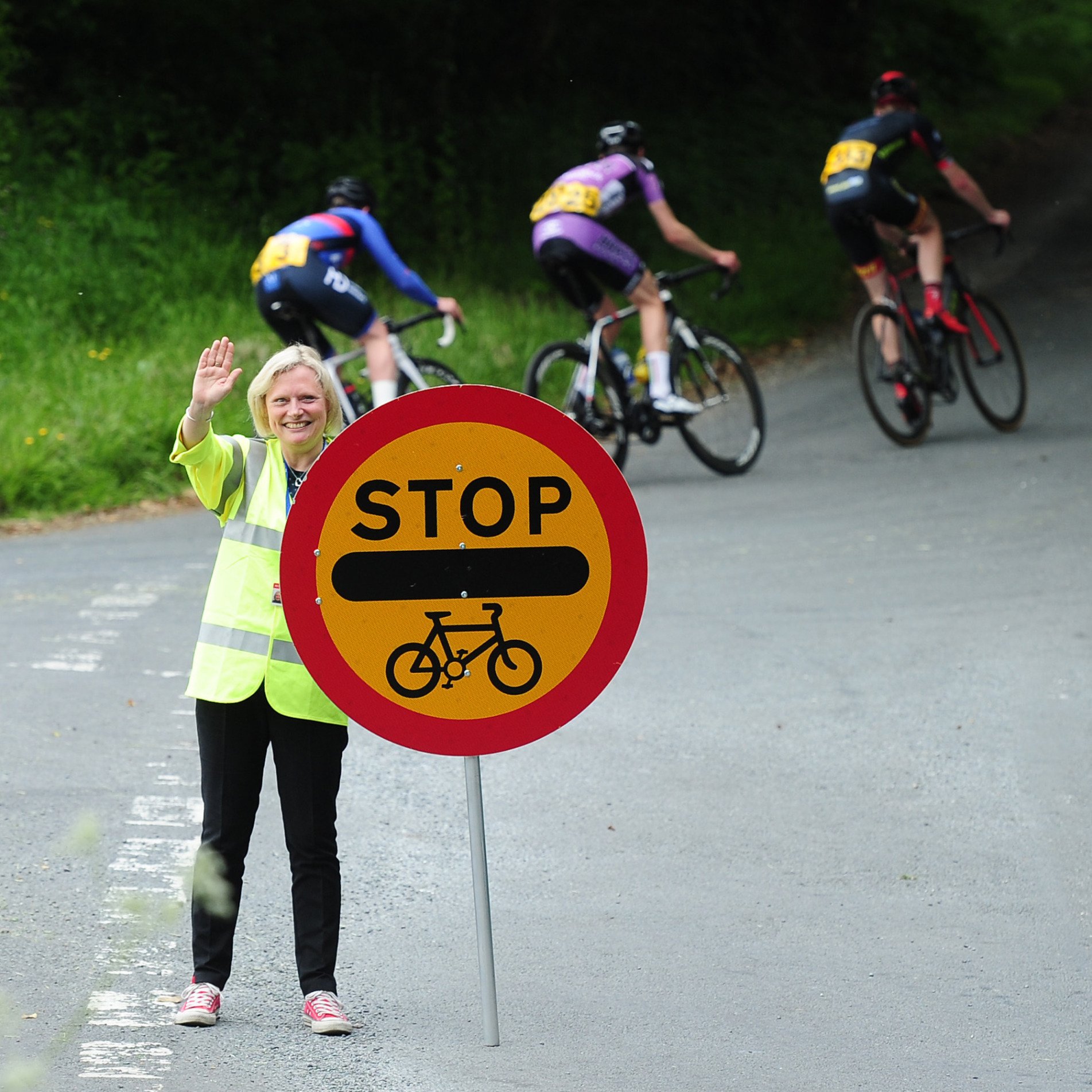 Accredited Marshal stopping traffic during cycling race